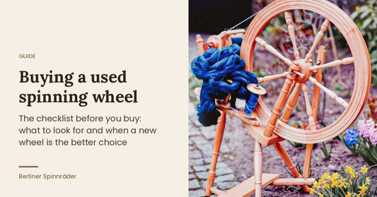 Buying a used spinning wheel: Kromski Prelude with blue wool in a garden